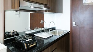 Eine Küche mit schwarzem Arbeitsplatz, Spüle aus Edelstahl und einem Rinnai-Gasherd.