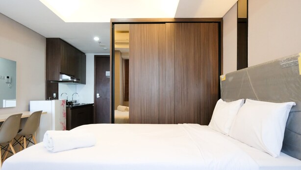 Ein Hotelzimmer mit Bett, Schreibtisch und einer Küchenzeile.