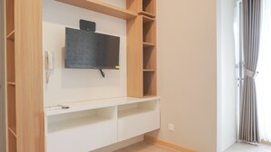 Ein modernes Zimmer mit integriertem Fernseher, Holzregalen und einem Telefon.