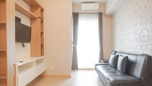 Ein modernes Wohnzimmer mit grauem Sofa, Holzregalen und einem Flachbildfernseher.