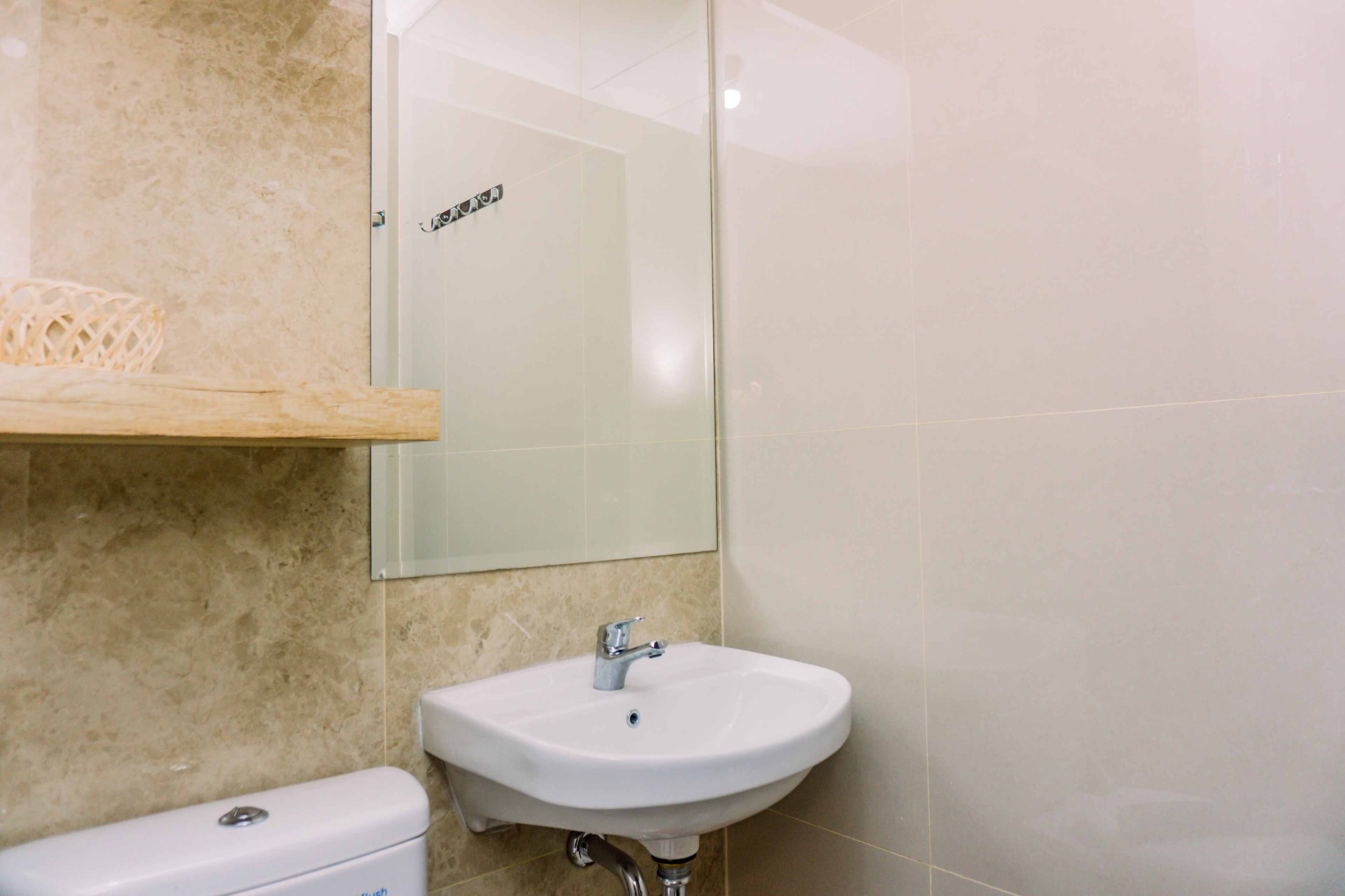 A bathroom with a white sink, a toilet, and a mirror.