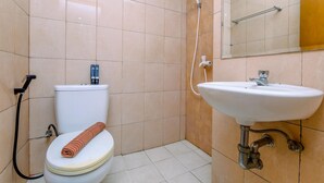 A bathroom with a toilet, a shower, and a sink. - Relaxing Studio Apartment At Margonda Residence 2 Near Ui (Depok)