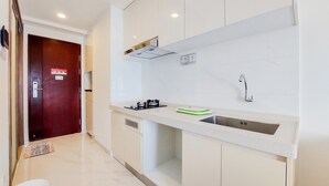 Una cocina moderna con armarios blancos, un lavamanos de acero inoxidable y una estufa a gas.