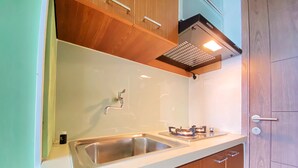 Una cocina con un lavamanos de acero inoxidable, armarios de madera y una campana extractora moderna.