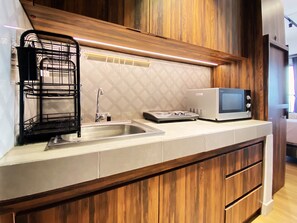 Studio | Private kitchen | Fridge, stovetop, cookware/dishes/utensils, dining tables - Comfort Studio Room At Mekarwangi Square Cibaduyut Apartment (Bandung)