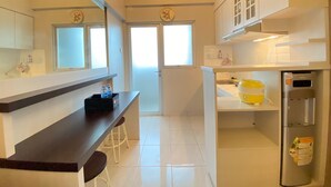 A modern kitchen with white cabinets, a stainless steel refrigerator, and a countertop with a yellow appliance. - Relaxing 1Br At Apartment At Newton Residence Bandung (Bandung)