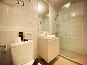 Enjoy a contemporary bathroom with a glass-enclosed shower, dual sink vanity, and ample storage.