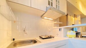 A modern kitchen with white cabinetry, a stainless steel sink, and a built-in stove. - Relaxing 1Br At Apartment At Newton Residence Bandung (Bandung)