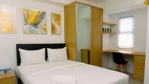 A neatly arranged bedroom with a bed, a desk, and a chair. - Cozy Studio At Urbantown Serpong Apartment (South Tangerang)