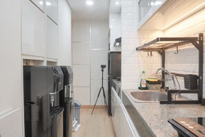Refrigerador, placa de cocina, utensilios de cocina, mesa de comedor