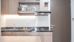 Una cocina moderna con una campana de acero inoxidable, un lavamanos doble y armarios de madera.