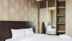 Une chambre d’hôtel avec un grand lit, une armoire avec un miroir et une petite étagère avec des articles de toilette.