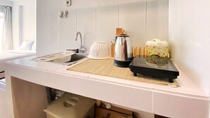 Una cocina moderna con un lavamanos, una tetera y una cafetera sobre la encimera.