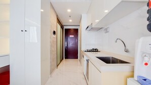 A modern kitchen with a marble countertop, a built-in sink, and a compact layout.