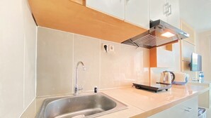 Una cocina moderna con un lavamanos de acero inoxidable, hervidor y tostadora.