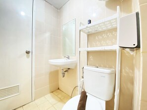Ein Badezimmer mit einem weißen Waschbecken, einem Spiegel, einer Toilette und einem Handtuch, das an der Wand hängt.