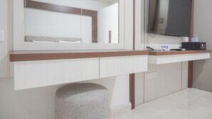 A modern bathroom with a vanity, mirror, and mounted television. - Fancy Designed Studio At Gold Coast Apartment (Jakarta)