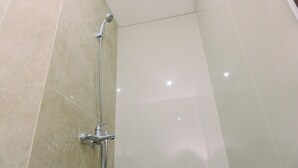 A bathroom with a shower area, tiled walls, and a visible showerhead. - Minimalist And Warm Studio At Transpark Bintaro Apartment (South Tangerang)