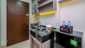 A modern kitchen with a black countertop, a coffee maker, and a water dispenser.