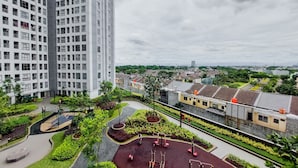 A high-rise residential building with a landscaped courtyard featuring exercise equipment and a small playground. - Nice Designed And Comfort 2Br Apartment At M-Town Residence (Gading Serpong)