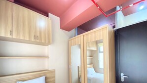 Un dormitorio con cama, armario de madera y una puerta.