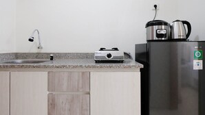Une cuisine dotée d’un plan de travail en granit, d’une cuisinière à gaz, d’un évier, d’un réfrigérateur en acier inoxydable et d’une bouilloire.