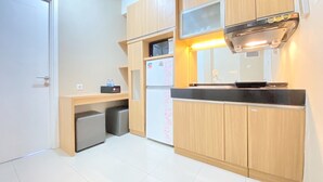 Une cuisine compacte avec des meubles en bois, un four à micro-ondes, un réfrigérateur et un petit évier.