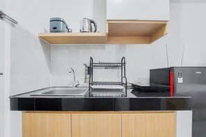 Studio | Private kitchen | Fridge, stovetop, cookware/dishes/utensils, dining tables - Nice And Simply Look Studio Serpong Garden Apartment (Cisauk)