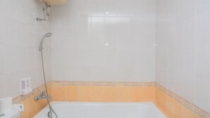 Une salle de bain avec une baignoire, une douche et des toilettes.