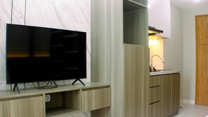 Eine moderne Küche mit integriertem Fernseher, Holzschränken und einer Marmor-Spritzschutzwand.