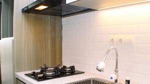 Eine moderne Küche mit einer Edelstahl-Spüle, einem Gasherd und einer Dunstabzugshaube.