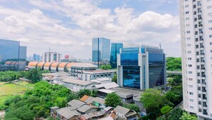 A cityscape with modern high-rise buildings, a mix of residential and commercial structures, and a green park area. - Cozy Studio At 8Th Floor Signature Park Grande Apartment (Jakarta)