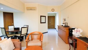 A hotel room with a dining area, a kitchen, and a living area. - Extra Spacious And Homey 2Br At Kondominium Puncak Marina Apartment (Surabaya)
