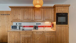 Eine Küche mit Holzschränken, einem Bosch-Ofen, einem Toaster und einem Wasserkocher.
