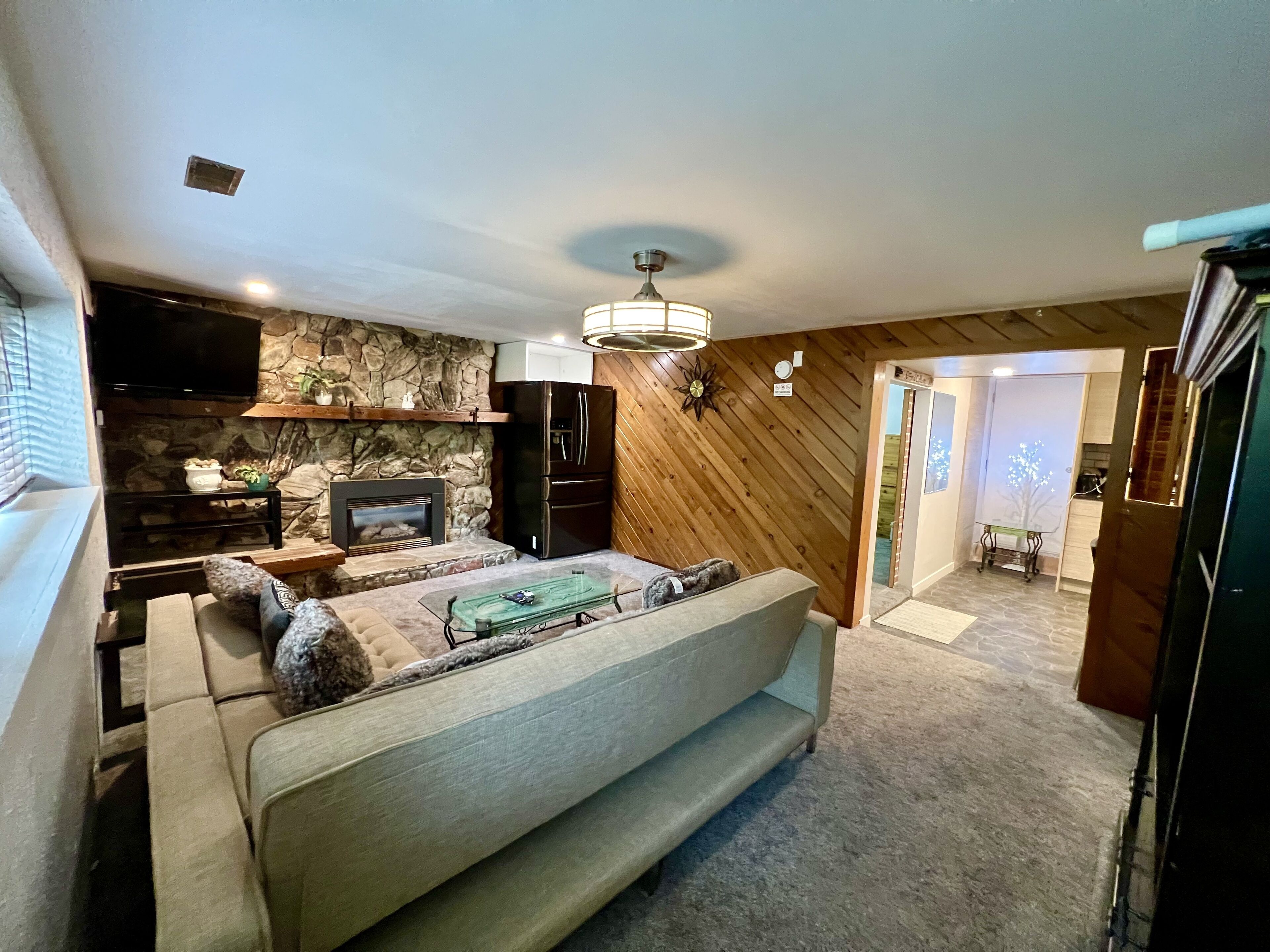 A cozy living room with a fireplace, a sofa, and a television.