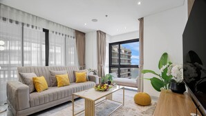 Een moderne woonkamer met een bank, salontafel en stadszicht.