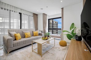 Departamento de lujo, 2 habitaciones, para no fumadores, vista al mar | Área de sala de estar | Smart TV de 50 pulgadas con canales por cable y televisión 