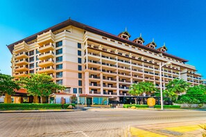 A multi-story hotel with a symmetrical facade, multiple balconies, and a central entrance.