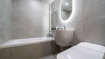 A modern bathroom with a bathtub, a sink, and a mirror.