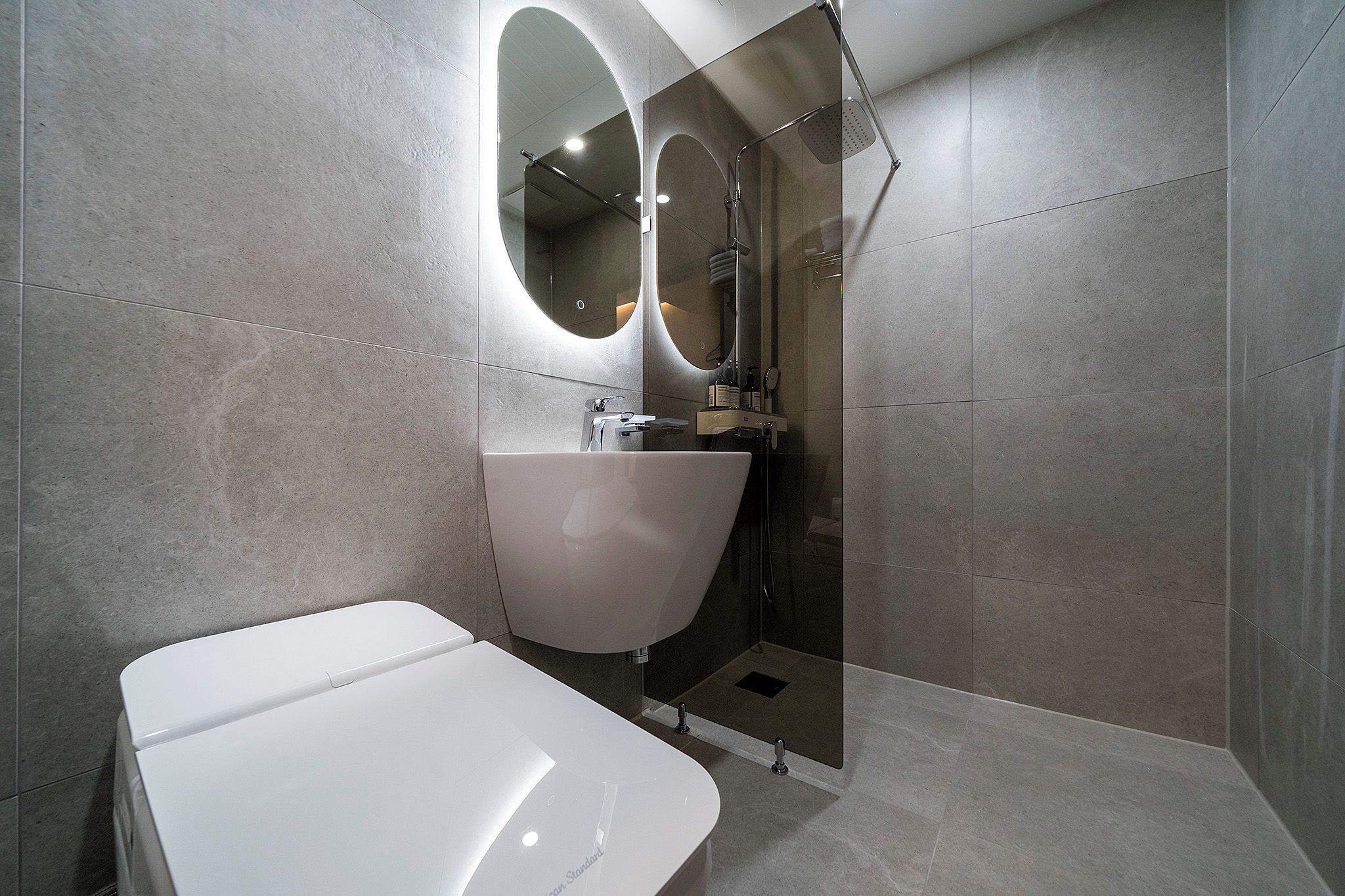 A modern bathroom with a freestanding bathtub, a large mirror, and a shower enclosure.