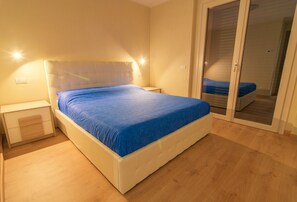 Cozy retreat with a large bed, nightstand, and sliding door to a separate room.