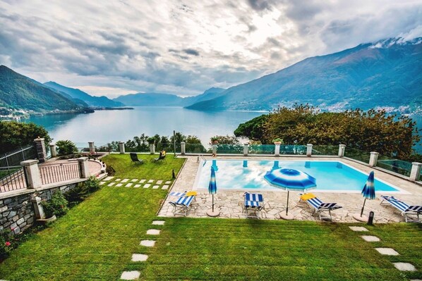 Relax by the serene pool surrounded by lush greenery and take in the breathtaking views of the lake and distant mountains.