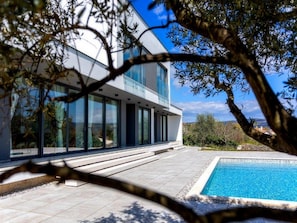 A modern house with a swimming pool, large windows, and a view of the countryside. - Martincic Residence (Marcana)