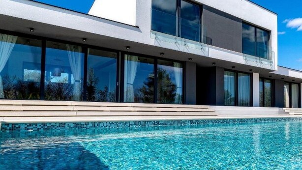 A modern building with a large glass facade and a swimming pool in front. - Martincic Residence (Marcana)