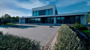 A modern two-story building with large windows and a spacious courtyard. - Martincic Residence (Marcana)
