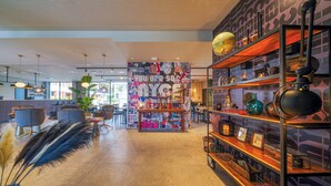 A modern interior with a central wall decorated with various posters and a bookshelf filled with decorative items. - PLAZA INN Ulm (Ulm)