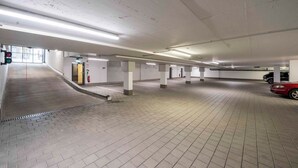 A multi-level parking garage with a ramp leading to an upper level. - PLAZA INN Ulm (Ulm)