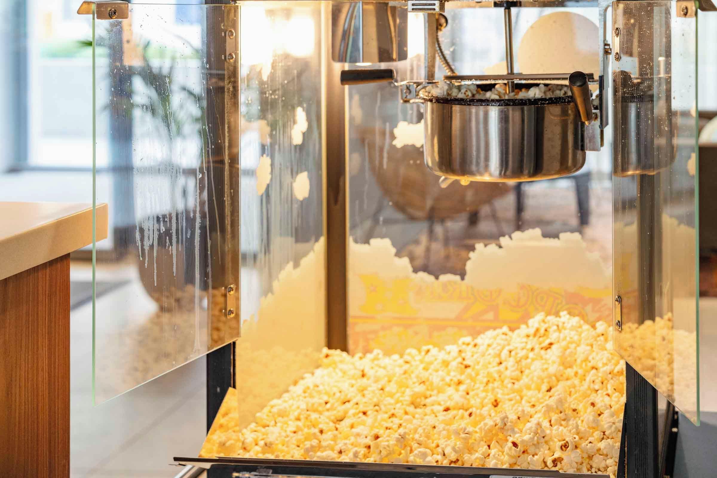 A popcorn machine with a transparent front, allowing visibility of the popcorn inside.