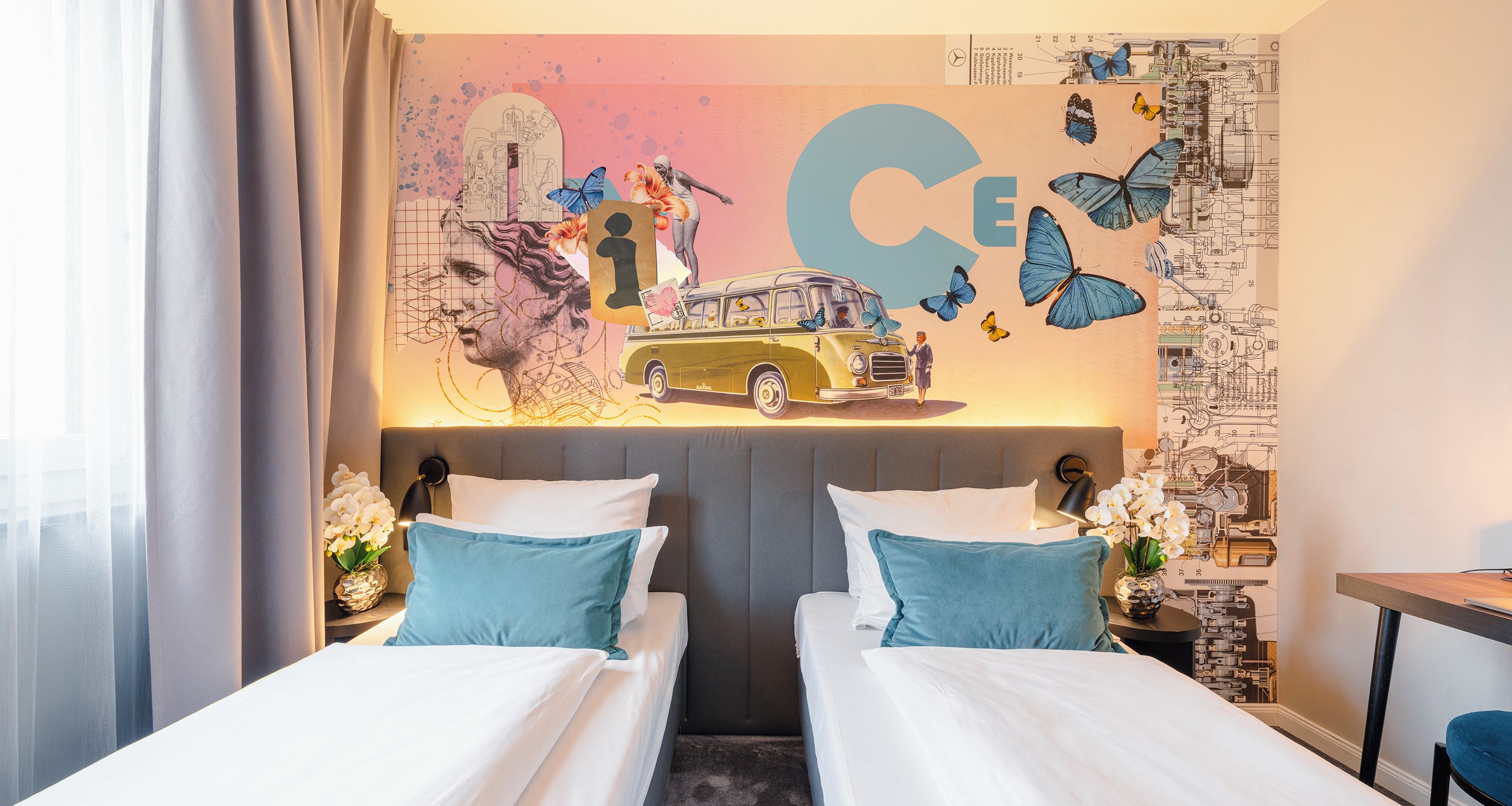 Una camera d'albergo con due letti, un grande murale e una scrivania.