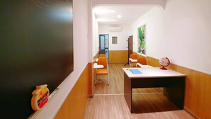 A classroom with a blackboard, wooden desks, and chairs. - Language Exchange Hotel 3 (Ho Chi Minh City)